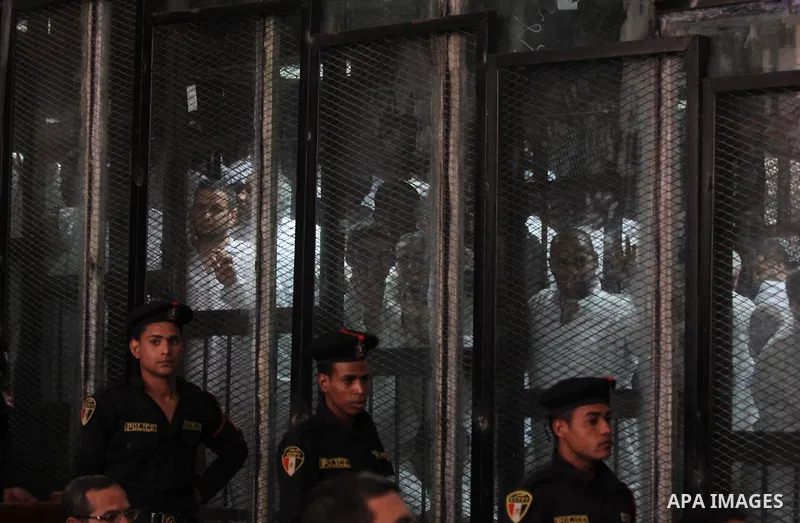 Egyptian Muslim Brotherhood members stand inside the defendants cage during their trial in the capital Cairo on May 17, 2016. Photo by Amr Sayed