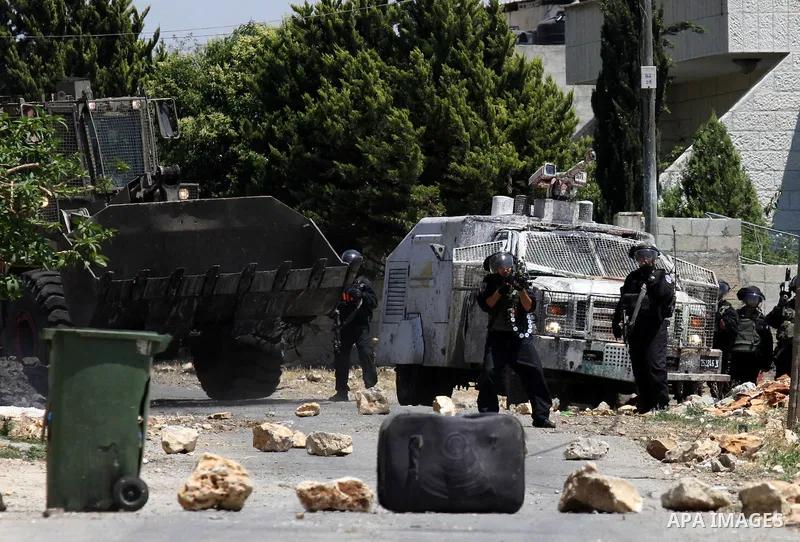 Israeli security forces stand guard next to their armoured vehicle during clashes with Palestinians following a demonstration against the expropriation of Palestinian land by Israel, on May 20, 2016 in the village of Kfa...