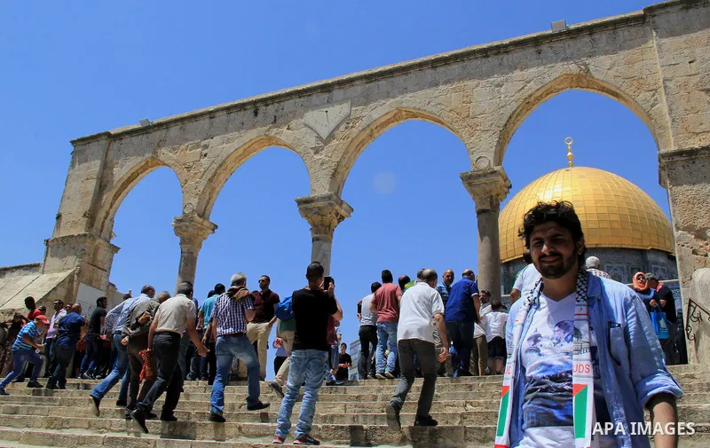 Palestinian Muslim worshipers walk in front of the Dome of the Rock mosque following Friday prayers at al-Aqsa mosque,Islam's third holiest site, in Jerusalem's Old city on May 20, 2016. Photo by Mahfouz Abu Turk