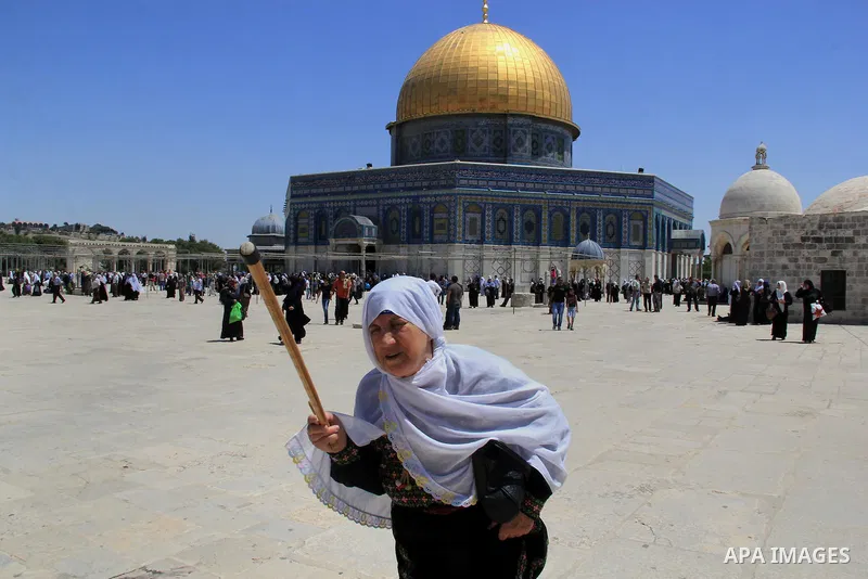 A Palestinian woman walks in front of the Dome of the Rock mosque following Friday prayers at al-Aqsa mosque,Islam's third holiest site, in Jerusalem's Old city on May 20, 2016. Photo by Mahfouz Abu Turk