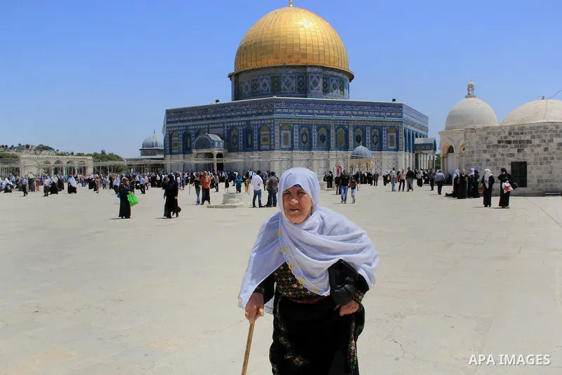 A Palestinian woman walks in front of the Dome of the Rock mosque following Friday prayers at al-Aqsa mosque,Islam's third holiest site, in Jerusalem's Old city on May 20, 2016. Photo by Mahfouz Abu Turk