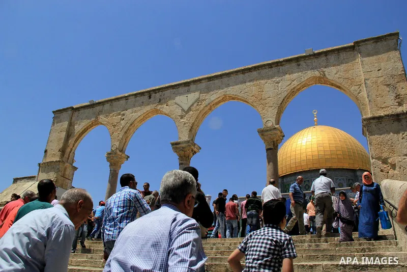 Palestinian Muslim worshipers walk in front of the Dome of the Rock mosque following Friday prayers at al-Aqsa mosque,Islam's third holiest site, in Jerusalem's Old city on May 20, 2016. Photo by Mahfouz Abu Turk