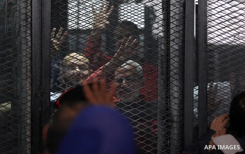 Egyptian Muslim Brotherhood members stand inside the defendants cage during their trial in the capital Cairo on May 21, 2016. Photo by Amr Sayed