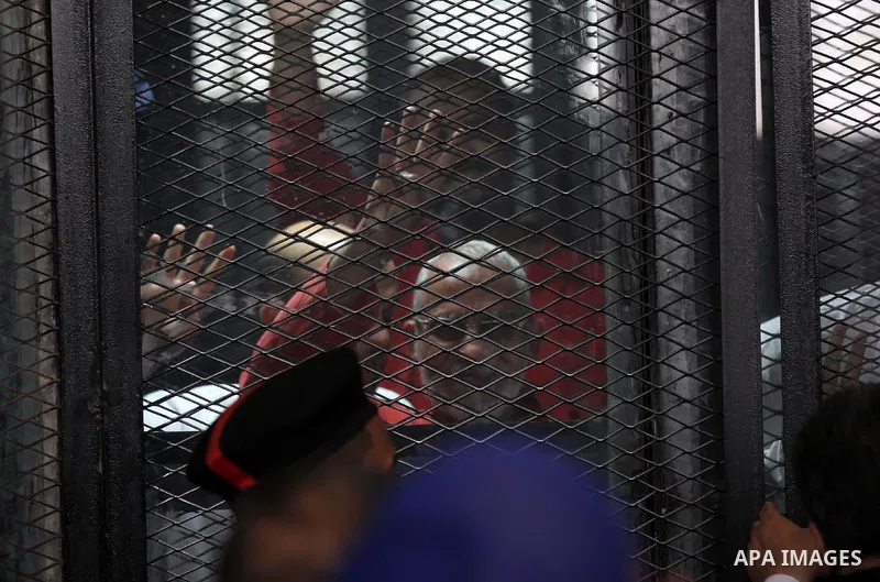 Egyptian Muslim Brotherhood members stand inside the defendants cage during their trial in the capital Cairo on May 21, 2016. Photo by Amr Sayed
