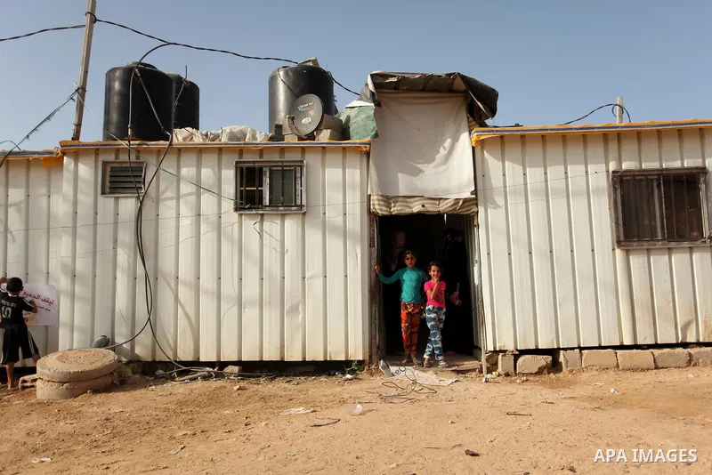 Palestinian women stand outside their temporary houses during a protest against the Israeli blockade of the Gaza Strip and demanding for reconstruction of houses which were destroyed during the recent Israeli war in Biet...
