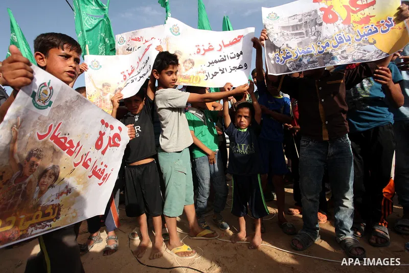 Palestinian children hold placards during a protest against the Israeli blockade of the Gaza Strip and demanding for reconstruction of houses which were destroyed during the recent Israeli war in Biet Hanoun in the north...