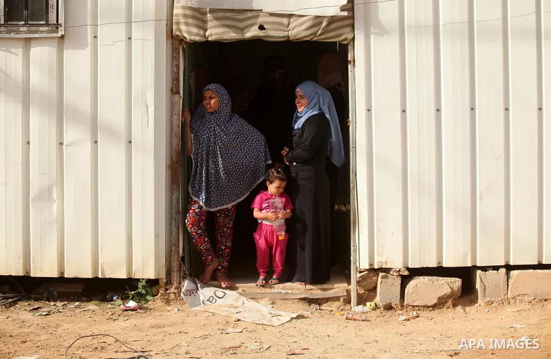 Palestinian women stand outside their temporary houses during a protest against the Israeli blockade of the Gaza Strip and demanding for reconstruction of houses which were destroyed during the recent Israeli war in Biet...