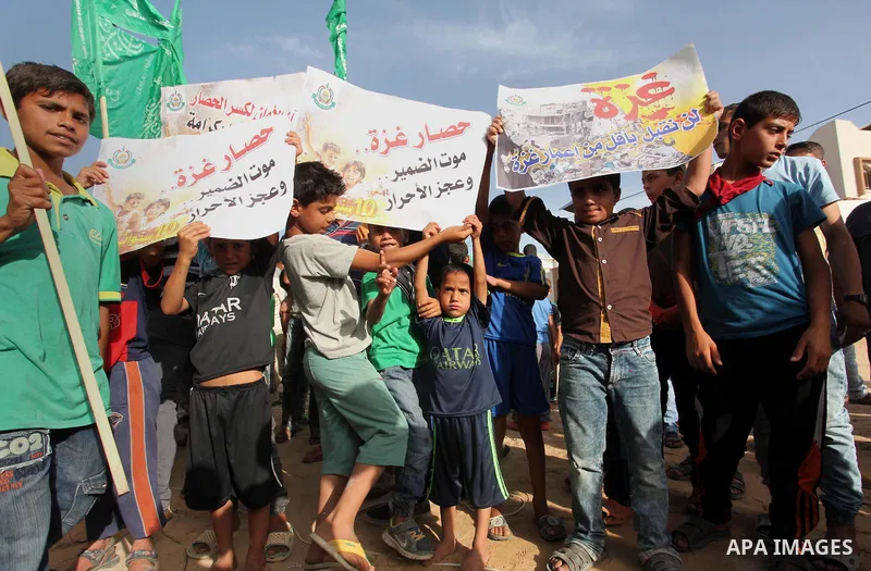 Palestinian children hold placards during a protest against the Israeli blockade of the Gaza Strip and demanding for reconstruction of houses which were destroyed during the recent Israeli war in Biet Hanoun in the north...