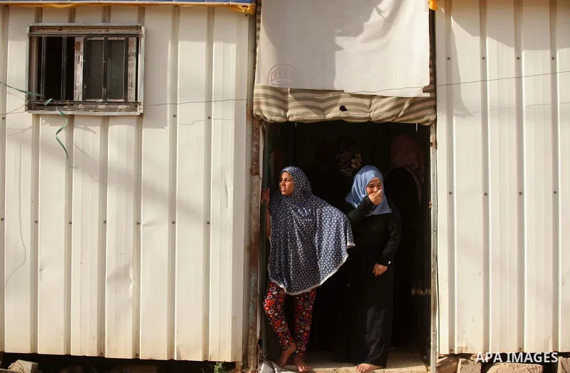 Palestinian women stand outside their temporary houses during a protest against the Israeli blockade of the Gaza Strip and demanding for reconstruction of houses which were destroyed during the recent Israeli war in Biet...