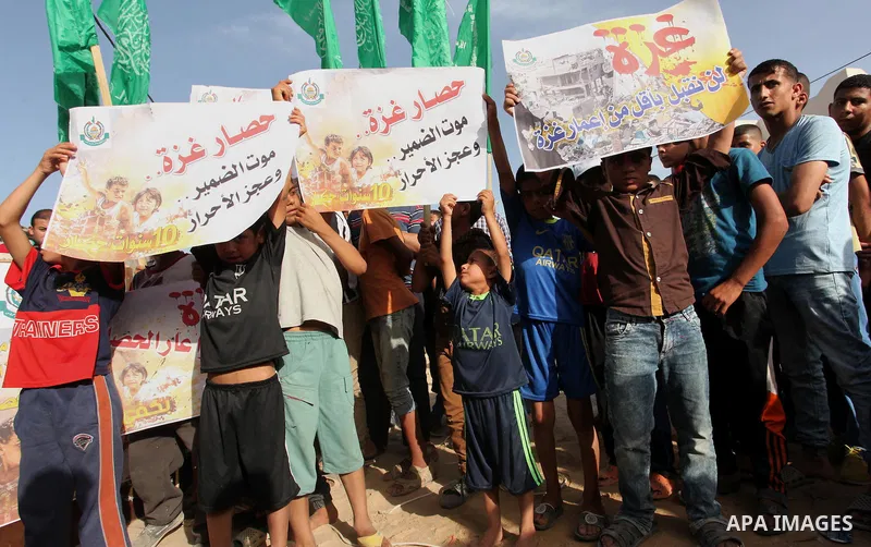 Palestinian children hold placards during a protest against the Israeli blockade of the Gaza Strip and demanding for reconstruction of houses which were destroyed during the recent Israeli war in Biet Hanoun in the north...