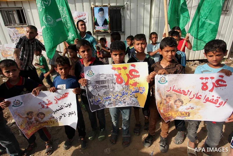 Palestinian children hold placards during a protest against the Israeli blockade of the Gaza Strip and demanding for reconstruction of houses which were destroyed during the recent Israeli war in Biet Hanoun in the north...