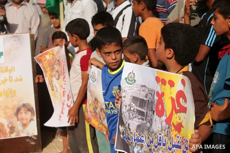 Palestinian children hold placards during a protest against the Israeli blockade of the Gaza Strip and demanding for reconstruction of houses which were destroyed during the recent Israeli war in Biet Hanoun in the north...
