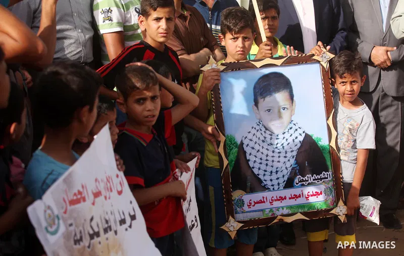 Palestinian children hold placards during a protest against the Israeli blockade of the Gaza Strip and demanding for reconstruction of houses which were destroyed during the recent Israeli war in Biet Hanoun in the north...