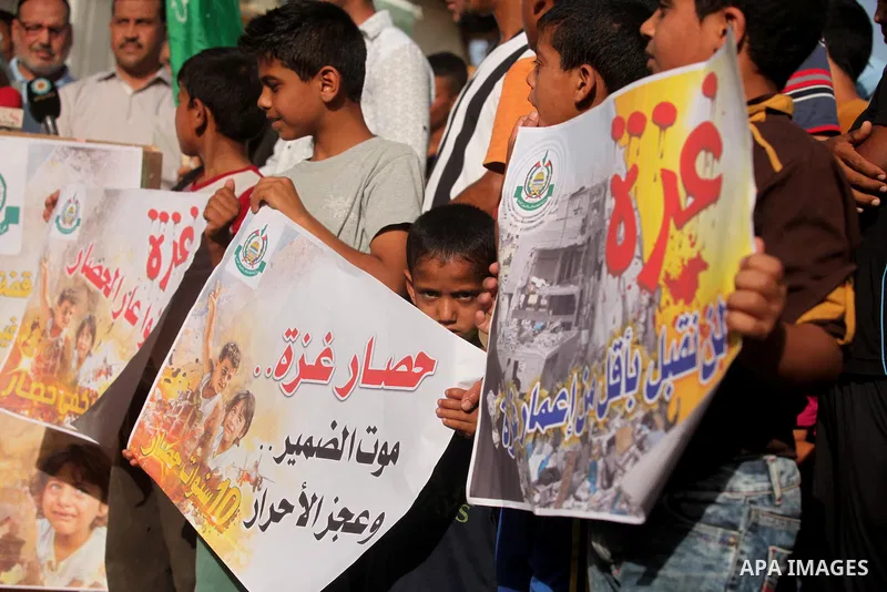 Palestinian children hold placards during a protest against the Israeli blockade of the Gaza Strip and demanding for reconstruction of houses which were destroyed during the recent Israeli war in Biet Hanoun in the north...