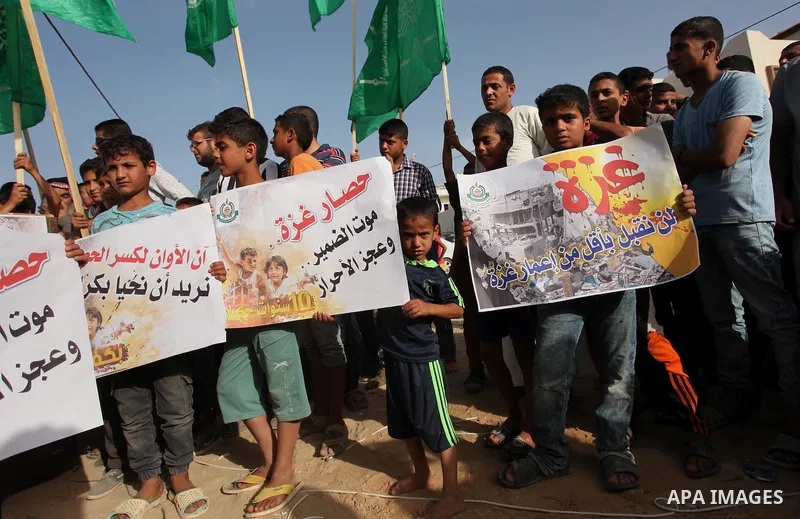 Palestinian children hold placards during a protest against the Israeli blockade of the Gaza Strip and demanding for reconstruction of houses which were destroyed during the recent Israeli war in Biet Hanoun in the north...