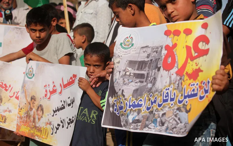 Palestinian children hold placards during a protest against the Israeli blockade of the Gaza Strip and demanding for reconstruction of houses which were destroyed during the recent Israeli war in Biet Hanoun in the north...