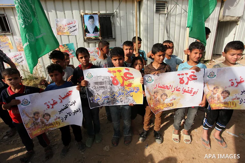 Palestinian children hold placards during a protest against the Israeli blockade of the Gaza Strip and demanding for reconstruction of houses which were destroyed during the recent Israeli war in Biet Hanoun in the north...