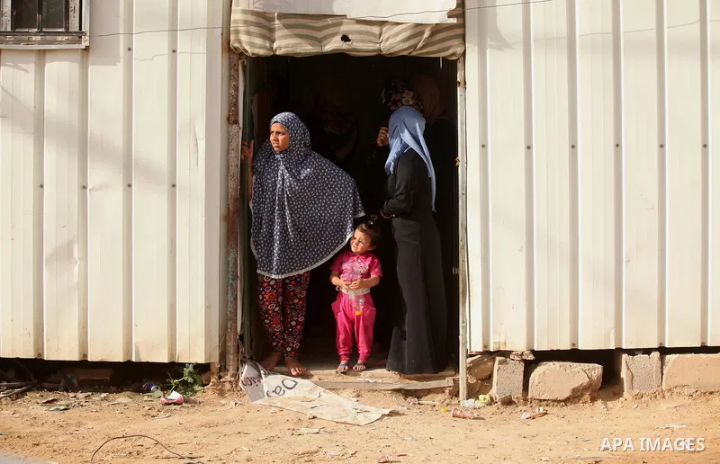 Palestinian women stand outside their temporary houses during a protest against the Israeli blockade of the Gaza Strip and demanding for reconstruction of houses which were destroyed during the recent Israeli war in Biet...