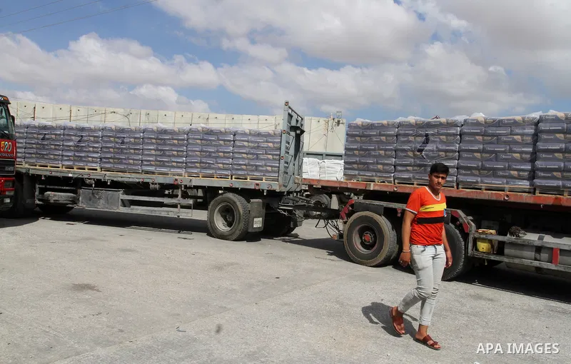 Palestinian workers stand on a truck loaded with bags of cement after it entered the southern Gaza Strip from Israel through the Kerem Shalom crossing in Rafah on May 23, 2016. Israel said on May 22 it was lifting a ban...