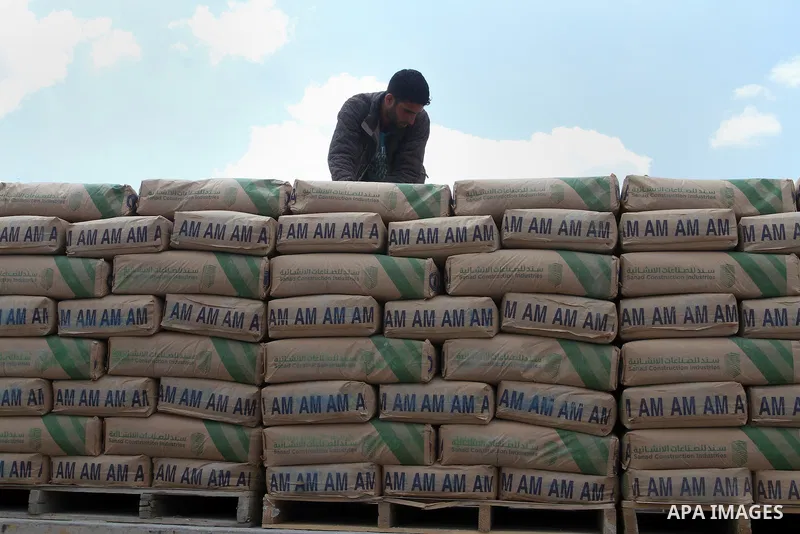 A Palestinian worker stands on a truck loaded with bags of cement after it entered the southern Gaza Strip from Israel through the Kerem Shalom crossing in Rafah on May 23, 2016. Israel said on May 22 it was lifting a ba...