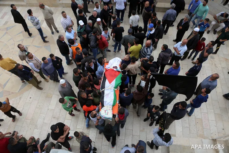 Mourners carry the body of Palestinian man Ibrahim Taha, who was shot dead by Israeli police along with his sister Maram Abu Ismail last month, during their funeral near the West Bank city of Ramallah May 23, 2016. Photo...