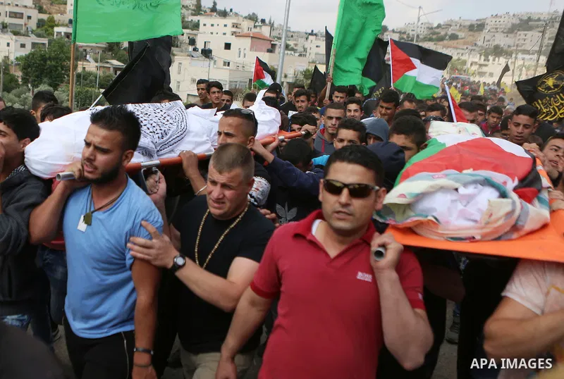 Mourners carry the bodies of Palestinian woman Maram Abu Ismail and her brother Ibrahim Taha, who were shot dead by Israeli police last month, during their funeral near the West Bank city of Ramallah May 23, 2016. Photo...