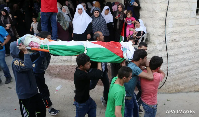Mourners carry the body of Palestinian man Ibrahim Taha, who was shot dead by Israeli police along with his sister Maram Abu Ismail last month, during their funeral near the West Bank city of Ramallah May 23, 2016. Photo...