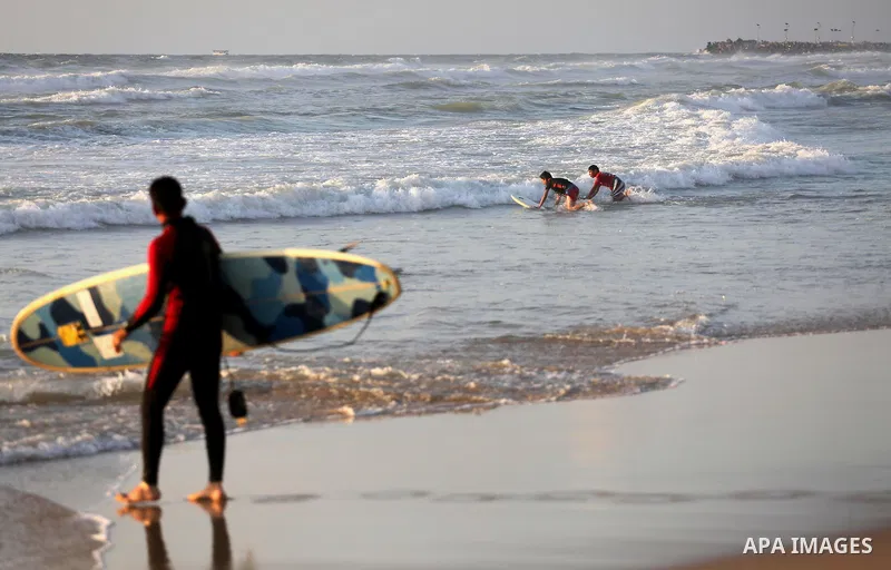 Palestinian youths enjoy a day at the beach of the Mediterranean sea on the coast of Gaza city during sunset, on May 24, 2016. Photo by Mohammed Asad