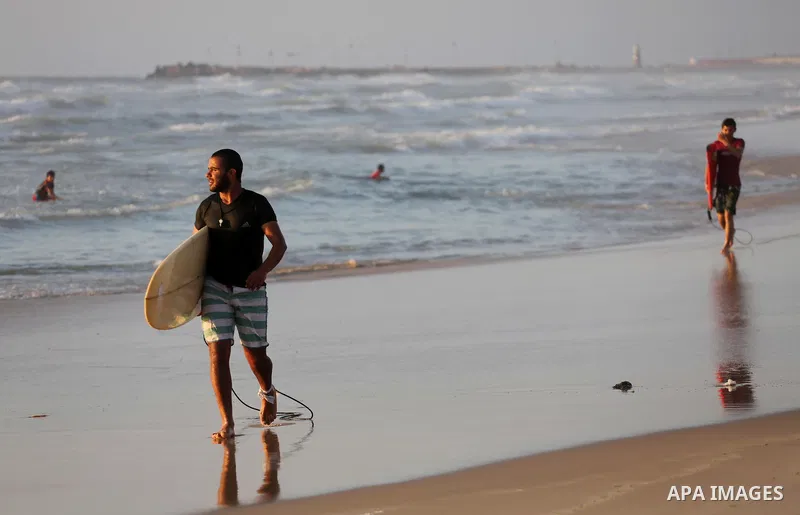 Palestinian youths enjoy a day at the beach of the Mediterranean sea on the coast of Gaza city during sunset, on May 24, 2016. Photo by Mohammed Asad