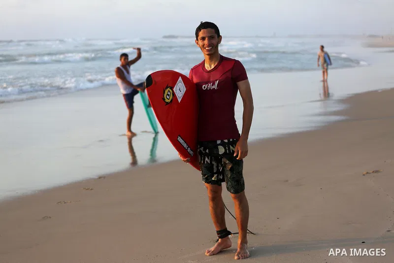 Palestinian youths enjoy a day at the beach of the Mediterranean sea on the coast of Gaza city during sunset, on May 24, 2016. Photo by Mohammed Asad