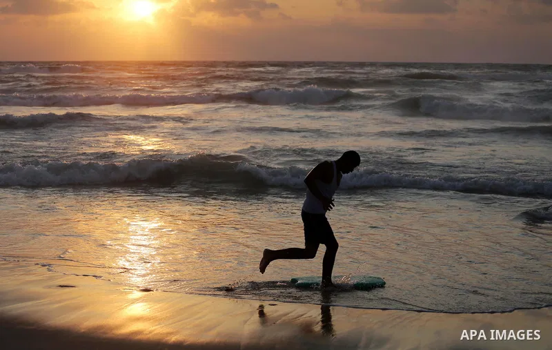 Palestinian youths enjoy a day at the beach of the Mediterranean sea on the coast of Gaza city during sunset, on May 24, 2016. Photo by Mohammed Asad