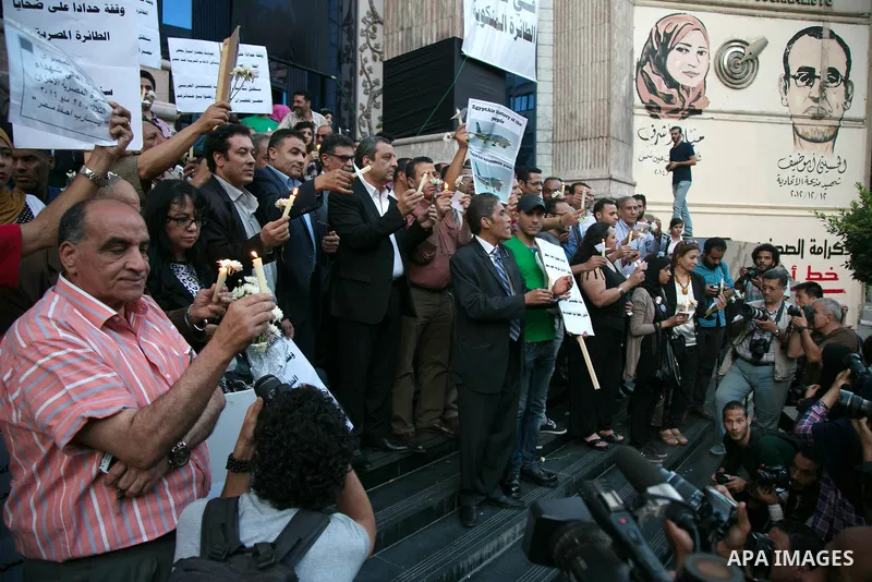 Egyptian journalists hold candles and placards supporting EgyptAir during a candlelight vigil for the victims of EgyptAir flight 804 in front of the Journalists' Syndicate in Cairo, Egypt, on May 24, 2016. The cause of T...