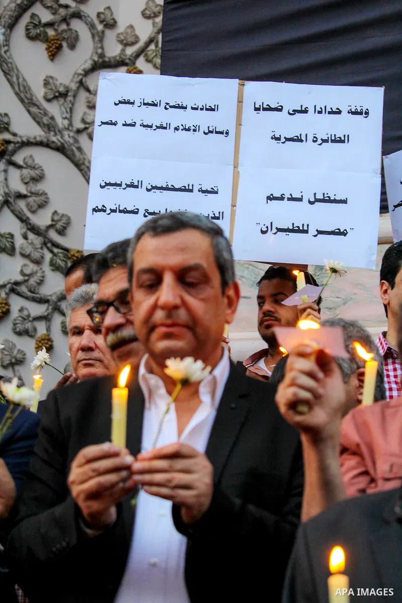 Egyptian journalists hold candles and placards supporting EgyptAir during a candlelight vigil for the victims of EgyptAir flight 804 in front of the Journalists' Syndicate in Cairo, Egypt, on May 24, 2016. The cause of T...