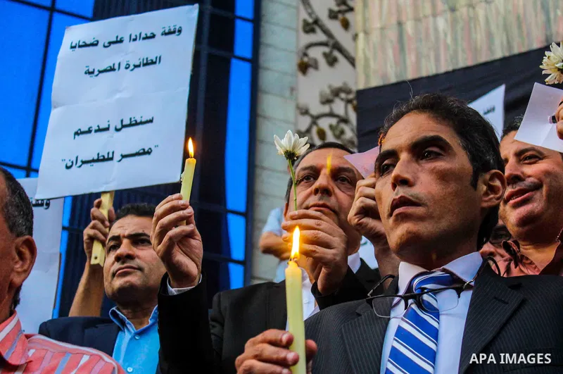 Egyptian journalists hold candles and placards supporting EgyptAir during a candlelight vigil for the victims of EgyptAir flight 804 in front of the Journalists' Syndicate in Cairo, Egypt, on May 24, 2016. The cause of T...