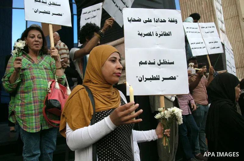 Egyptian journalists hold candles and placards supporting EgyptAir during a candlelight vigil for the victims of EgyptAir flight 804 in front of the Journalists' Syndicate in Cairo, Egypt, on May 24, 2016. The cause of T...