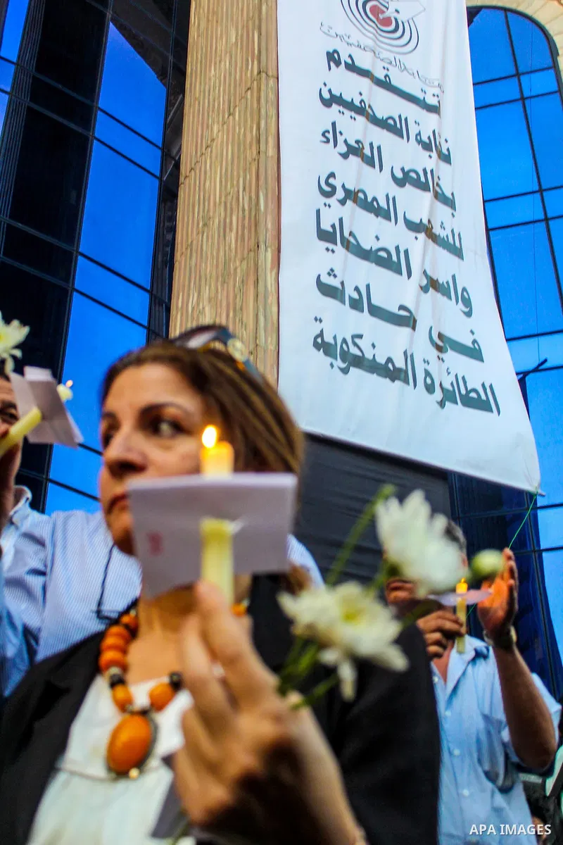 Egyptian journalists hold candles and placards supporting EgyptAir during a candlelight vigil for the victims of EgyptAir flight 804 in front of the Journalists' Syndicate in Cairo, Egypt, on May 24, 2016. The cause of T...