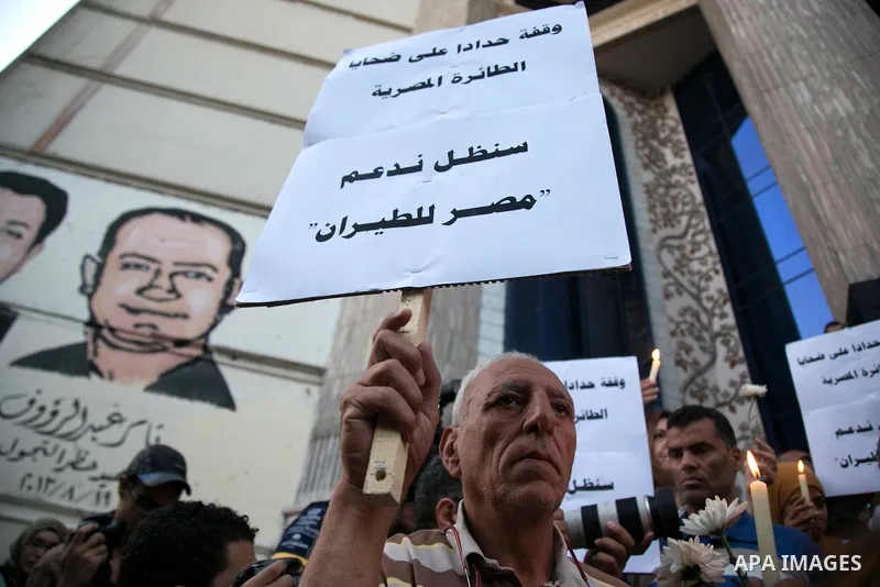 Egyptian journalists hold candles and placards supporting EgyptAir during a candlelight vigil for the victims of EgyptAir flight 804 in front of the Journalists' Syndicate in Cairo, Egypt, on May 24, 2016. The cause of T...