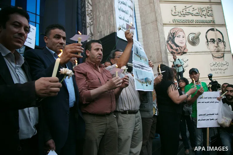 Egyptian journalists hold candles and placards supporting EgyptAir during a candlelight vigil for the victims of EgyptAir flight 804 in front of the Journalists' Syndicate in Cairo, Egypt, on May 24, 2016. The cause of T...