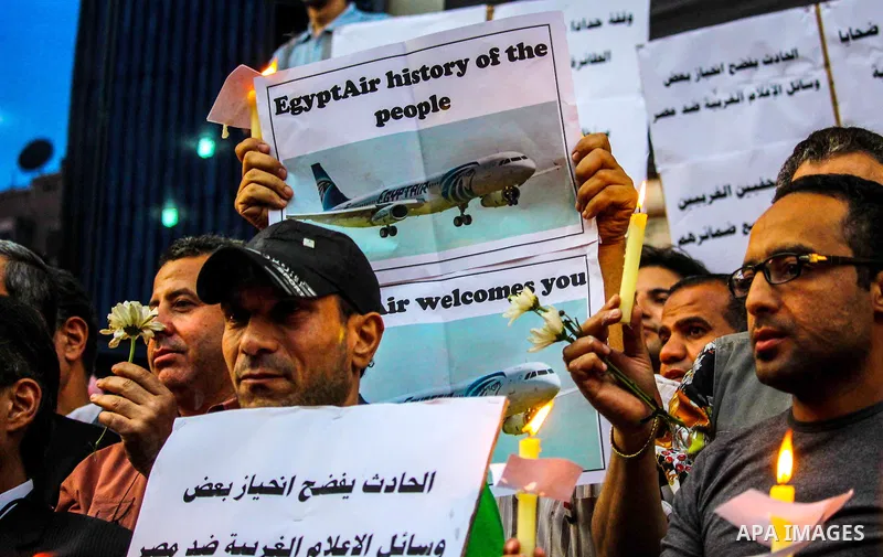 Egyptian journalists hold candles and placards supporting EgyptAir during a candlelight vigil for the victims of EgyptAir flight 804 in front of the Journalists' Syndicate in Cairo, Egypt, on May 24, 2016. The cause of T...