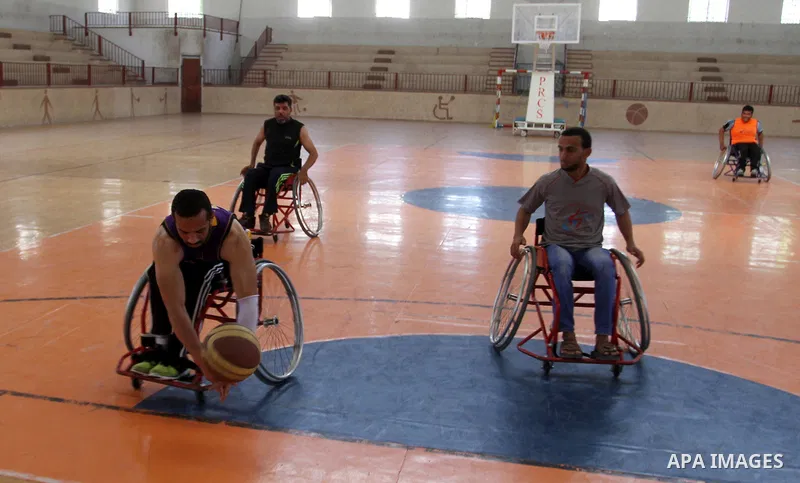 An American coach Jess marc, trains disabled Palestinians to play a basketball in Khan Younis in the southern Gaza strip, on May 26, 2016. Photo by Abed Rahim Khatib