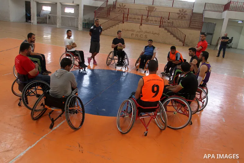 An American coach Jess marc, trains disabled Palestinians to play a basketball in Khan Younis in the southern Gaza strip, on May 26, 2016. Photo by Abed Rahim Khatib