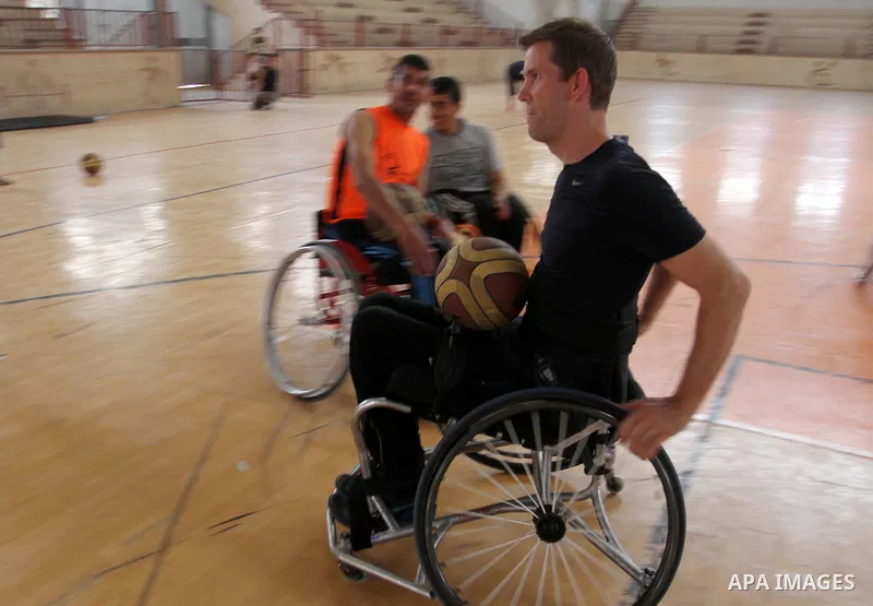 An American coach Jess marc, trains disabled Palestinians to play a basketball in Khan Younis in the southern Gaza strip, on May 26, 2016. Photo by Abed Rahim Khatib