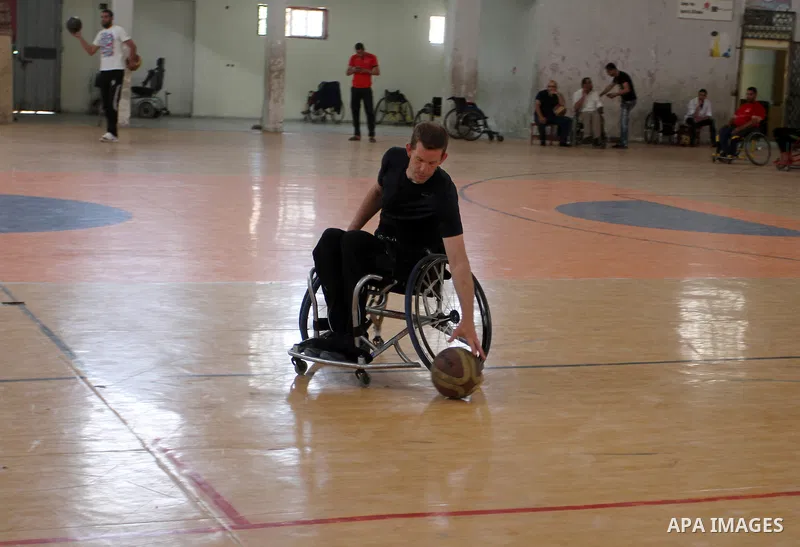 An American coach Jess marc, trains disabled Palestinians to play a basketball in Khan Younis in the southern Gaza strip, on May 26, 2016. Photo by Abed Rahim Khatib
