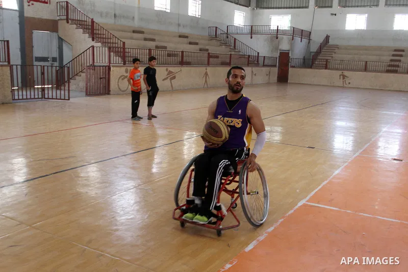 An American coach Jess marc, trains disabled Palestinians to play a basketball in Khan Younis in the southern Gaza strip, on May 26, 2016. Photo by Abed Rahim Khatib