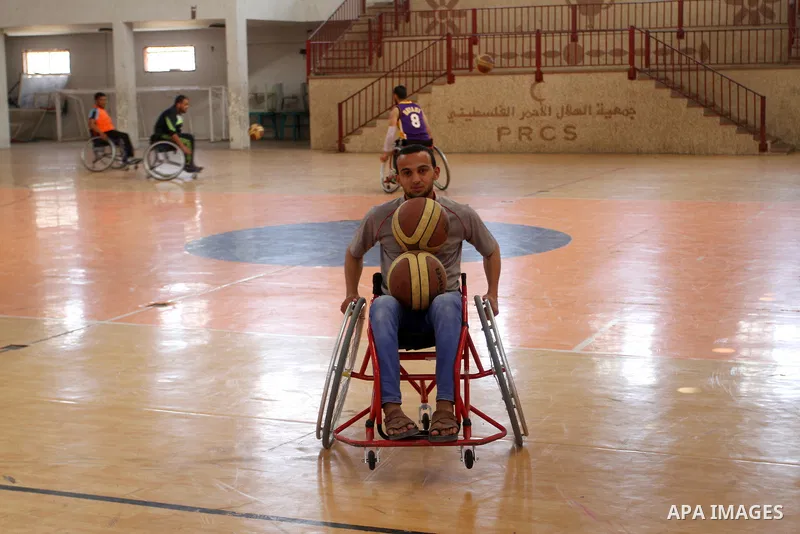 An American coach Jess marc, trains disabled Palestinians to play a basketball in Khan Younis in the southern Gaza strip, on May 26, 2016. Photo by Abed Rahim Khatib