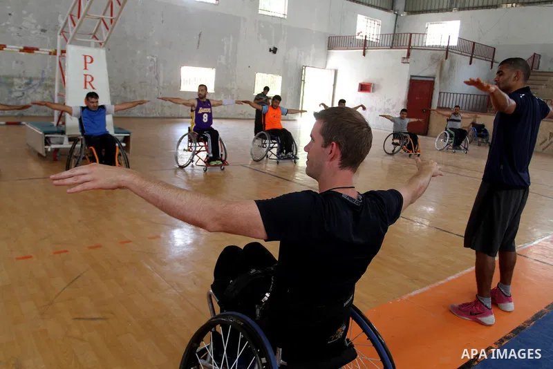 An American coach Jess marc, trains disabled Palestinians to play a basketball in Khan Younis in the southern Gaza strip, on May 26, 2016. Photo by Abed Rahim Khatib
