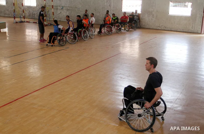 An American coach Jess marc, trains disabled Palestinians to play a basketball in Khan Younis in the southern Gaza strip, on May 26, 2016. Photo by Abed Rahim Khatib