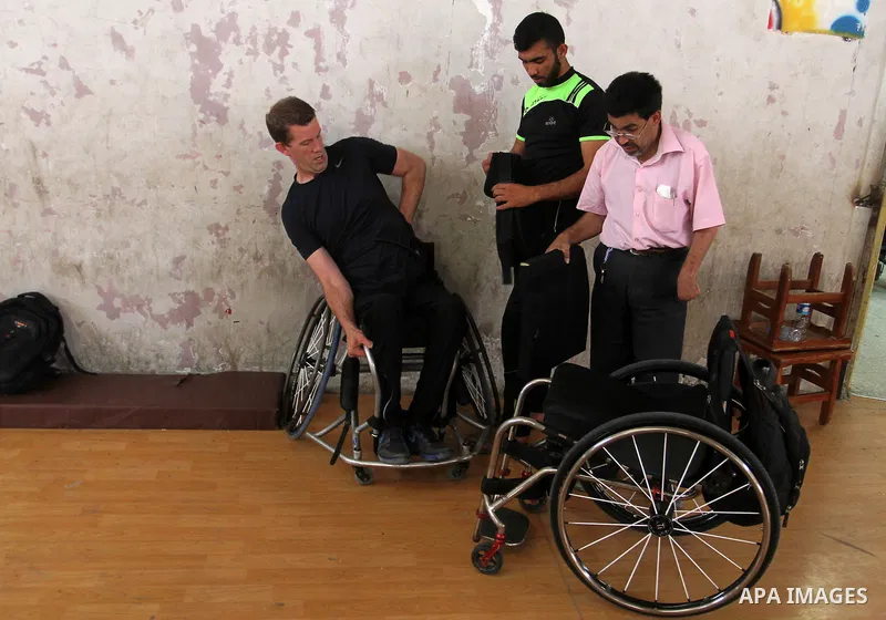 An American coach Jess marc, trains disabled Palestinians to play a basketball in Khan Younis in the southern Gaza strip, on May 26, 2016. Photo by Abed Rahim Khatib