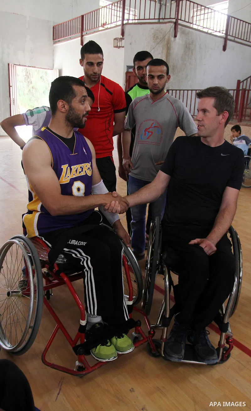 An American coach Jess marc, trains disabled Palestinians to play a basketball in Khan Younis in the southern Gaza strip, on May 26, 2016. Photo by Abed Rahim Khatib