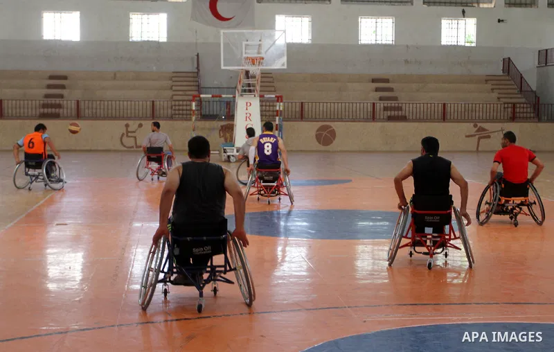 An American coach Jess marc, trains disabled Palestinians to play a basketball in Khan Younis in the southern Gaza strip, on May 26, 2016. Photo by Abed Rahim Khatib